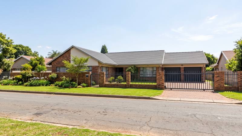 A single-storey face-brick East Rand home with a double garage and a brick boundary wall.