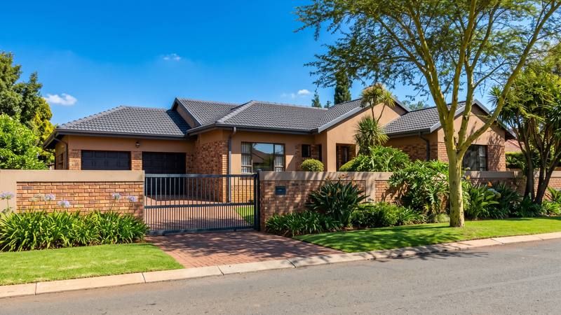 A face-brick Pretoria home with a tiled roof, a garden wall and a sliding gate.
